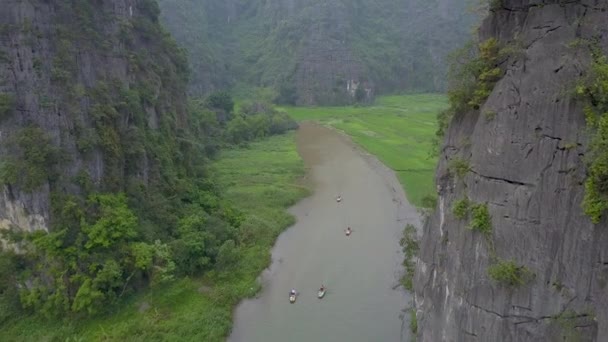 乘坐船只在游客上方飞行 划过农村越南风景如画的石灰岩悬崖和稻田 平静河流周围热带岩溶构造的风景如画的景色 — 图库视频影像