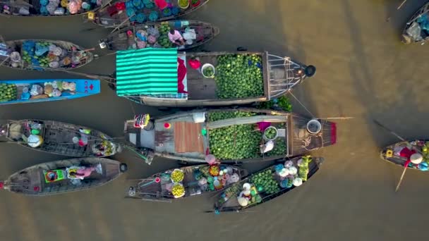 トップダウン 地元の人々は 濁った水に浮かぶ木製のボートから果物や野菜を売買しています 美しい晴れた夜にベトナムの田舎の牧歌的な地元の生活の風光明媚な景色 — ストック動画