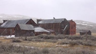 Bodie, Nevada, soğuk kış şartları ayrışma terk edilmiş ahşap evler. Yavaş yavaş pastoral hayalet kasaba ve geniş kırsal kapsayan kar taneleri. Güzel kırsal ülke ve eski maden köyü.