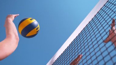 Slow Motion, Close Up, Low Angle: Bilinmeyen plaj voleybolcusu topu blokerin kollarını ve ellerini geçti. Güneşli bir yaz gününde voleybol oynayan tanınmamış sporcuların serin çekimi..