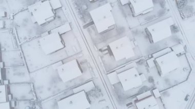 Anteni, üst aşağı: Blizzard kapakları çatılar ve asfalt yollarda sakin varoşlarda. Yollar karla kaplı sokaklara ve pastoral köyün özel özellikleri yukarıda uçan.