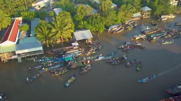 ハイパーラプス 地元のベトナム人は 濁った川の周りに浮かぶクールな木製のボートでビジネスをしています 晴れた夜にベトナムの田舎の牧歌的な浮遊市場の周りを飛ぶ — ストック動画