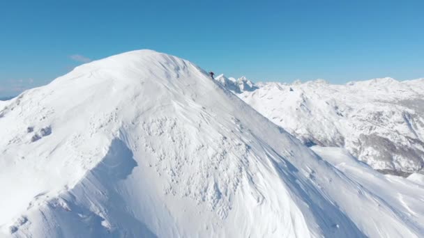 Aerial Unrecognizable Skier Hiking Snowy Mountain Sunny Winter Cinematic Shot — Stock Video