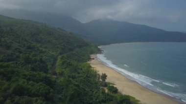 drone: yemyeşil tropik adada güzel kumlu plaj boyunca uçan. Vietnam'da pastoral dağları kapsayan yoğun egzotik orman yukarıdan Muhteşem görünümü. Nefes kesen ada manzarası.