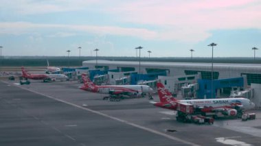 Hanoi Havaalanı, Vietnam, Mart 2017: Hanoi uluslararası havaalanından çıkan jet köprülerine bağlı uçaklardan oluşan Air Asia filosunun sinematik çekimi. Üç ticari uçak biniş