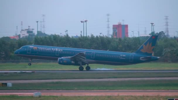 ハノイ空港 ベトナム 2017年3月 スローモーション ベトナム航空の飛行機が着陸し その車輪の後ろに煙の痕跡を残します 晴れた日にハノイに着陸する飛行機の映画撮影 — ストック動画