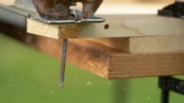 Yapboz bir iş parçasını keserken metal bir bıçaktan talaş uçar..