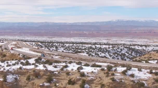 DRONE: Vista aérea de caminhões dirigindo ao longo da auto-estrada que atravessa deserto ventoso — Vídeo de Stock