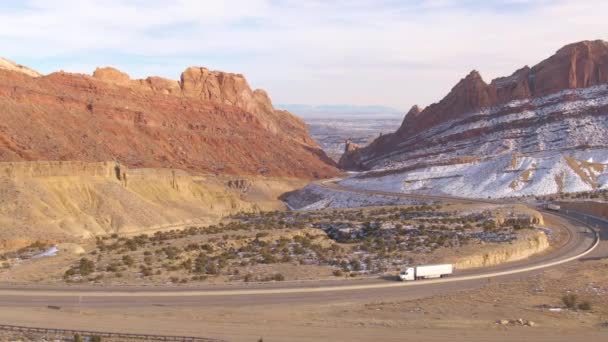 DRONE: Flying towards an asphalt freeway leading a truck along a wintry canyon. — Stock Video