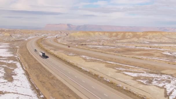 DRONE: Voando acima do equipamento grande que transporta um recipiente de frete através do deserto wintry — Vídeo de Stock
