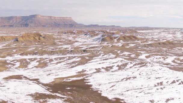 AERIAL: Vliegen over besneeuwde woestijn en naar bergen in de staat Utah. — Stockvideo