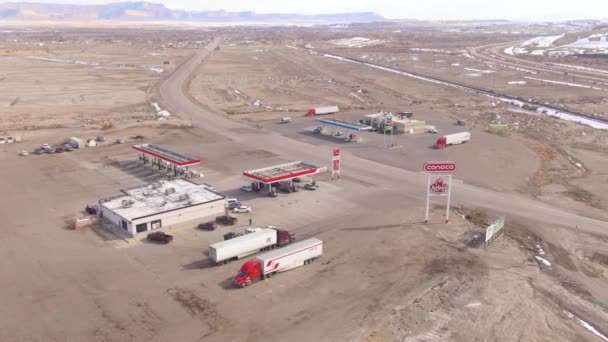 AERIAL: Voando acima de um ConocoPhillips e Chevron postos de gasolina no deserto . — Vídeo de Stock