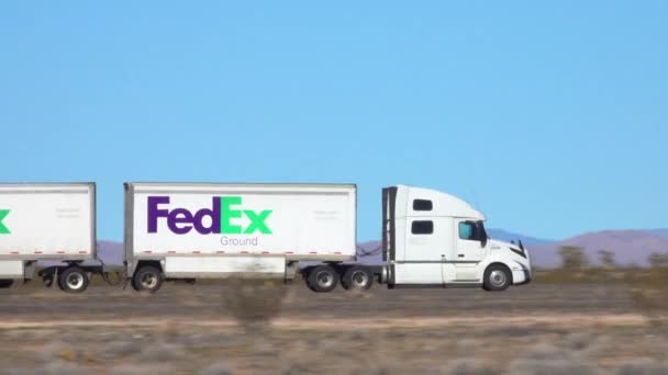 CERRAR Las velocidades de los camiones FedEx a lo largo de una carretera interestatal que cruza el desierto de Utah — Vídeos de Stock