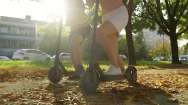 Tanımlanamayan iki kadın canlı caddelerde e-scooter sürmeye başladı..