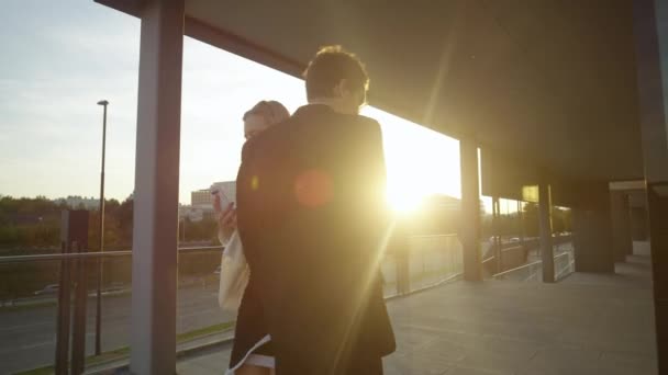 LENS FLARE: Zakenman maakt ruzie met vrouw na botsing met haar bij zonsondergang. — Stockvideo