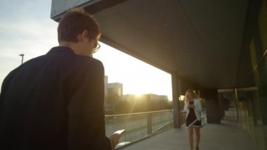 Yakışıklı yuppi, akıllı telefonlara bakan bir kadının ona çarpmasından sonra gülümser.