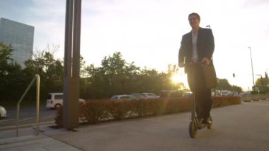 İşadamı, e-scooterıyla finans bölgesinde turluyor..