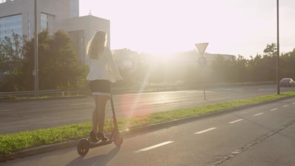 LENS FLARE : Une femme d'affaires méconnaissable fait du scooter électrique pour travailler au lever du soleil. — Video
