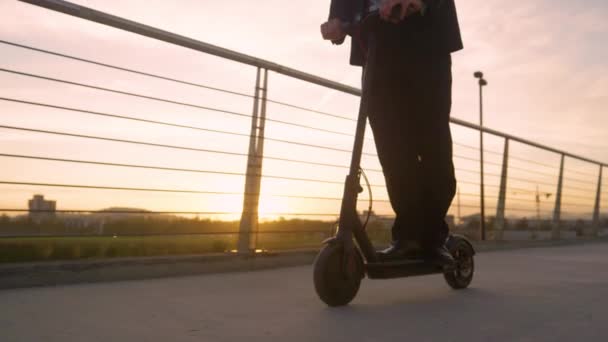 Κοντινό πλάνο: Σύγχρονη επιχειρηματίας απολαμβάνει μια βόλτα στο σπίτι από την εργασία σε ένα e-scooter. — Αρχείο Βίντεο