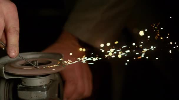 CLOSE UP, DOF: Sparks fly off spinning angle grinder grinding a piece of metal. — Stock Video