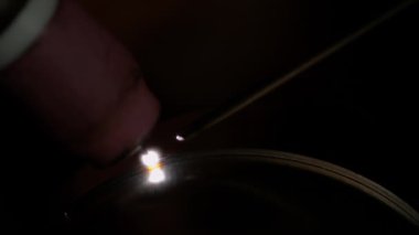 MACRO Metal işçisi bir susturucu yaparken iki parça titanyumu birleştirir.