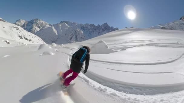 FOLLOW: Fresca ragazza snowboarder brandelli di neve fresca che copre le montagne canadesi — Video Stock