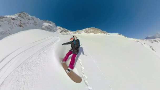 SELFIE: Kobieta snowboardzistka rzeźbi w nietkniętą górę w słoneczny dzień. — Wideo stockowe