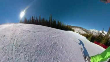 Snowboardcu eğlence parkında sürerken vuruculara çarpar ve numaralar yapar.