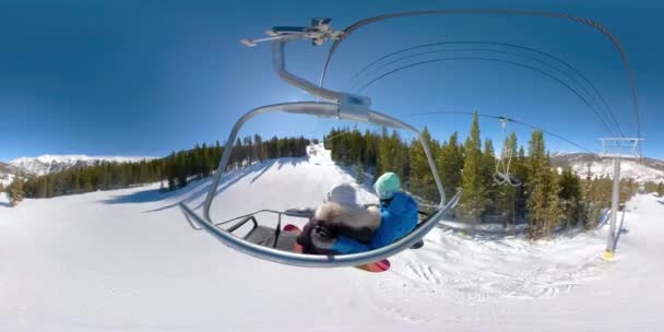 360VR: Young snowboarders ride the chairlift and observe the stunning nature. — Stock Video