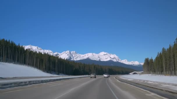 POV: Rijden over de snelweg met een schilderachtig uitzicht op een besneeuwde bergkam — Stockvideo