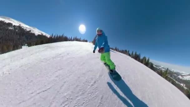 Havalı snowboardcu, güneşli bir kış gününde bakımlı yamaçları parçalıyor.. — Stok video