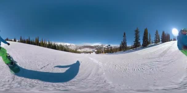 360 VR: Stoked snowboarder shredding the ski slopes sprays snow at the camera. — Stock Video