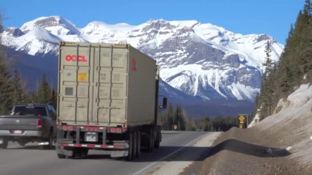 Stor 18 hjuling och bilar kör ner den berömda Icefields Parkway på en solig dag. — Stockvideo