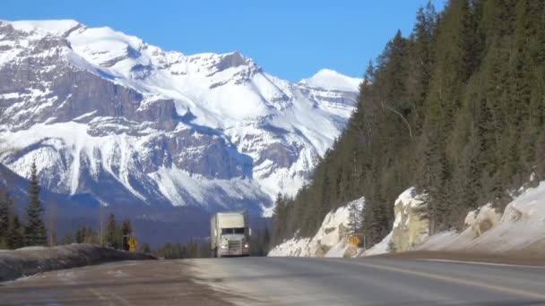 Semi-trailer truck and car drive along the highway crossing Jasper National Park — Stock Video