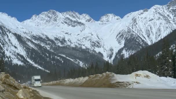 LOW ANGLE: Een konvooi van vrachtauto 's en auto' s rijden over de schilderachtige weg. — Stockvideo
