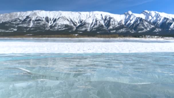 Uzavřít, DOF: Scénický záběr zasněženého ledovce za zamrzlým jezerem v Albertě. — Stock video