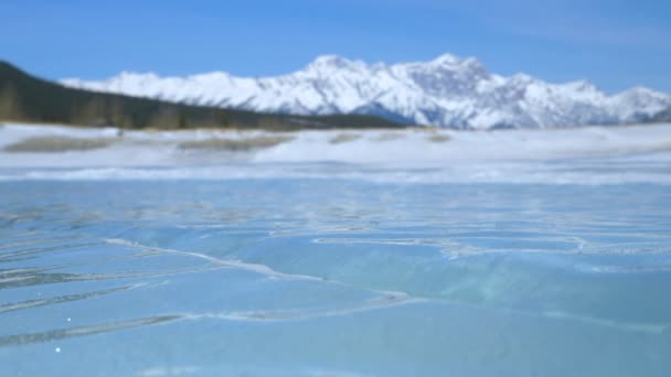 CLOSE UP: Detailed view of smooth surface of frozen Lake Abraham on a sunny day. — Stock Video