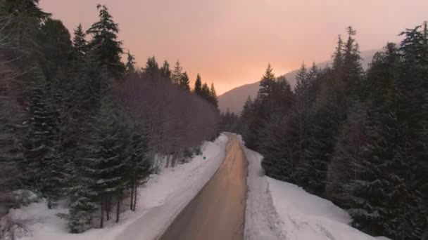 AERIAL: An einem sonnigen Winterabend am leeren Sea to Sky Highway entlang fliegen. — Stockvideo