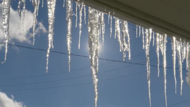 CLOSE UP: Große glasige Eiszapfen sind über Nacht an der Außenseite eines Fensters gewachsen. — Stockvideo