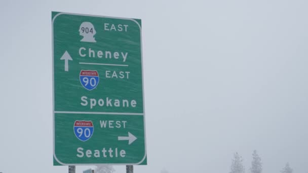 CLOSE UP Groen verkeersbord stuurt verkeer rond Washington tijdens een sneeuwstorm — Stockvideo