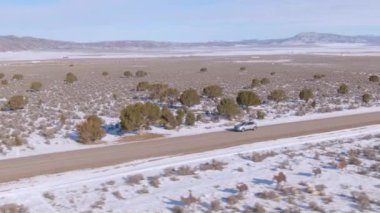 Utah 'tan geçen boş otoyolda gümüş rengi bir SUV ile uçuyorum..