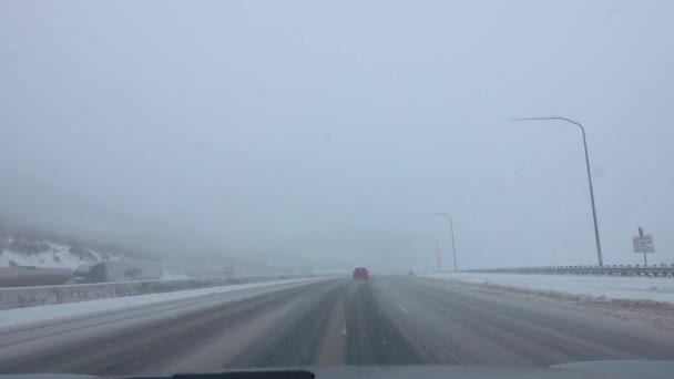 POV: Driving down an icy and snowy interstate freeway during an extreme blizzard — Stock Video