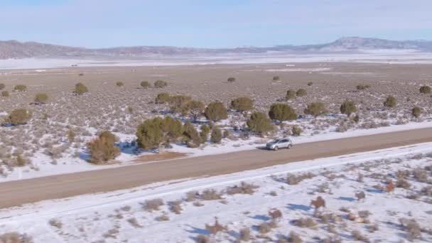 DRONE: Voando ao longo de um SUV de prata cruzando a auto-estrada vazia que atravessa Utah. — Vídeo de Stock