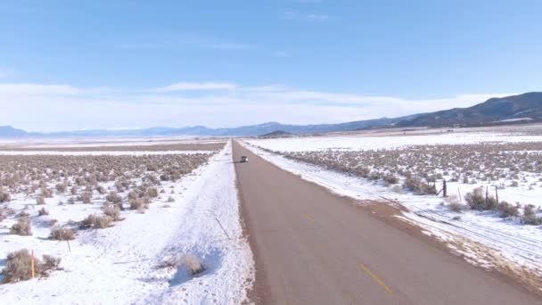 DRONE: i turisti in SUV esplorano le pianure innevate dello Utah in una giornata invernale soleggiata — Video Stock