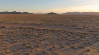 Mojave çölünde altın gün batımında bir SUV 'un üzerinde uçmak..