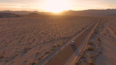 SUV ünlü Mojave çölünü geçiyor, muhteşem Kaliforniya günbatımında..