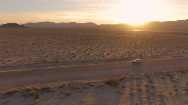 AERIAL: Zlaté kalifornské sluneční paprsky osvětlují krajinu pro SUV na výletě — Stock video