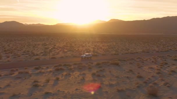 Літаючи над позашляховиком, що пролітає через пустелю Мохаве на заході сонця.. — стокове відео