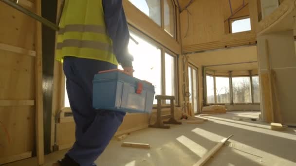 FECHAR UP: construtor irreconhecível chega ao trabalho carregando sua caixa de ferramentas e escada — Vídeo de Stock