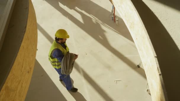 Contratista de movimiento lento atrapa tubería de instalación eléctrica que cae desde arriba — Vídeos de Stock